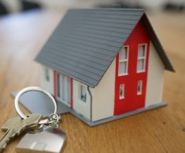 Photo by Tierra Mallorca white and red wooden house miniature on brown table